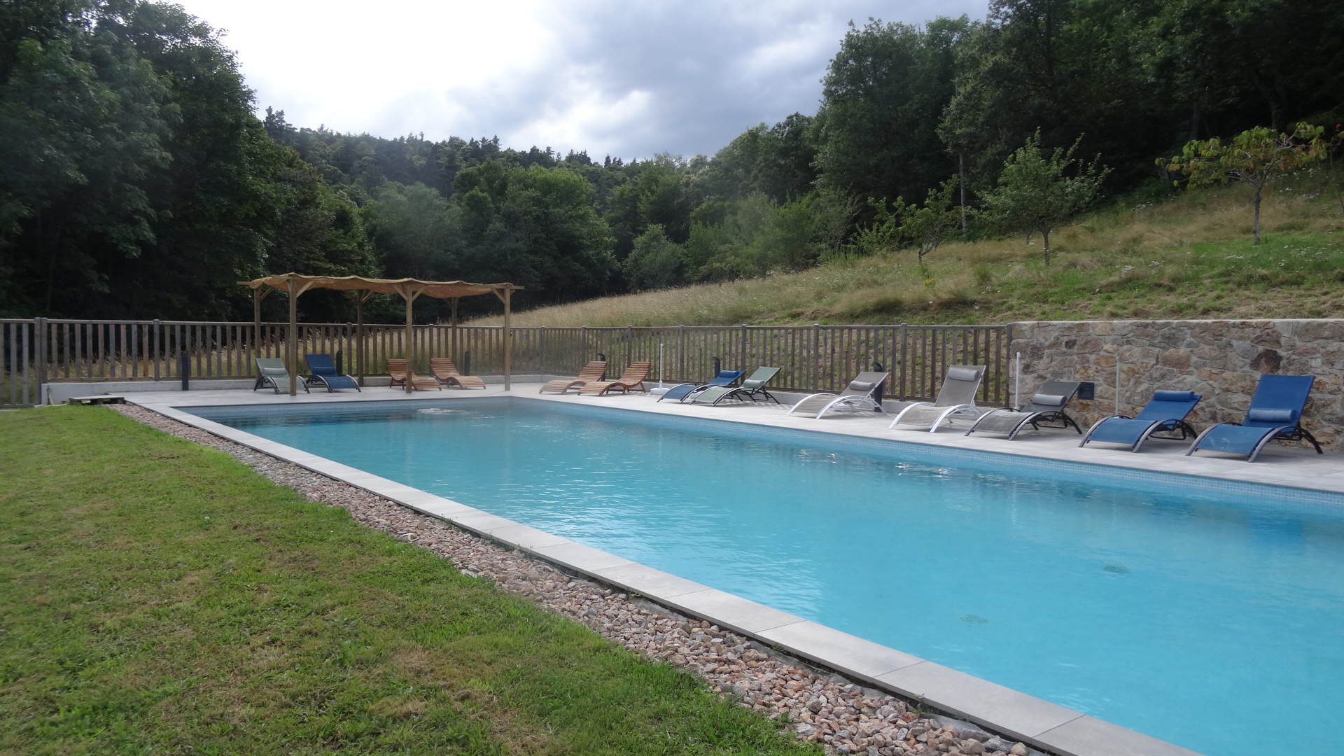 la piscine est en lisière de forêt elle dispose d'une terrasse avec chaises longues et espace ombragé